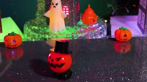 An pumpkin pops up in front of a rotating house surrounded by a pumpkin figure Stock-Footage 346601743