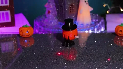A pumpkin pops out against of house featuring surrounded glowing ghost figures Stock Footage 346601710