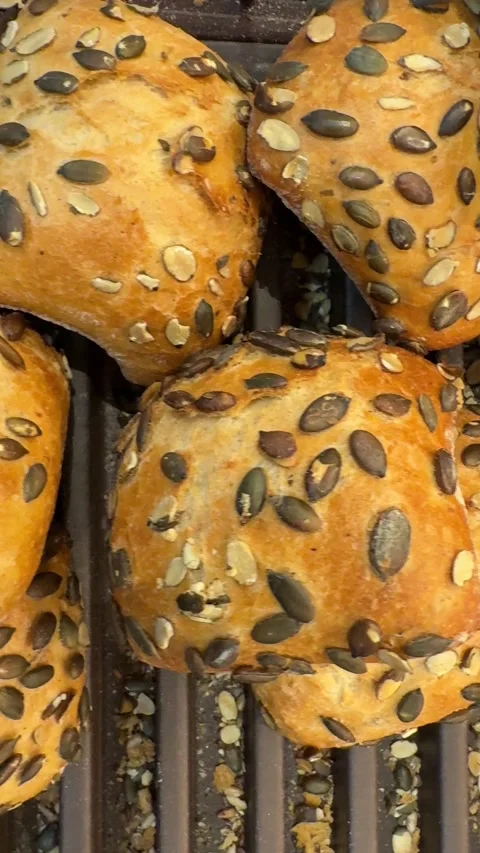 Pumpkin seed bread rolls freshly baked in bakery display Video stock 317321116