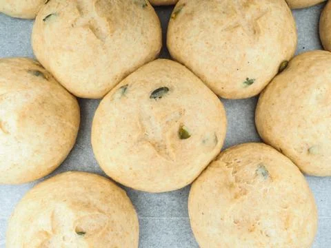 Pumpkin seed buns proofed on baking paper Stock Photos
