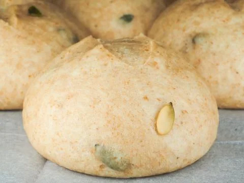 Pumpkin seed buns proofed on baking paper Stock Photos