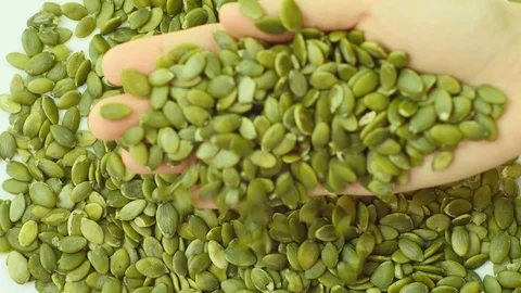 Pumpkin seed falling from hand. Stock Footage 89613075