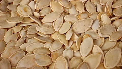Pumpkin seed seeds closeup texture video on rolling rotating looping plate Stock Footage 104326178