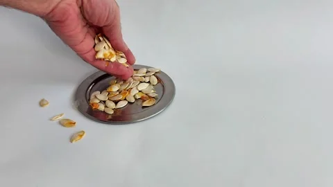 Pumpkin Seeds Cascading from Hand into Silver Dish, Top View Stock-Footage 320042115