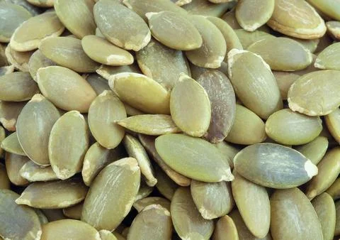 Pumpkin seeds close up on background. Stock Photos