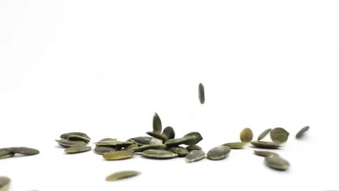 Pumpkin seeds fall against white background (Slowmo) Stock-Footage 82071339