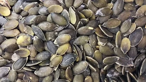 Pumpkin seeds fall on pile from above (Slowmo) Stock-Footage 82071175