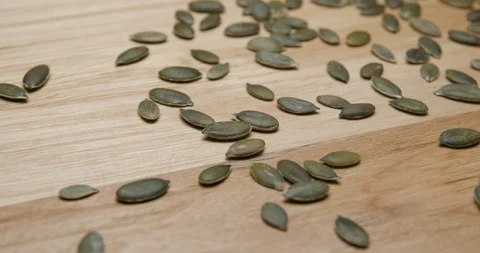 Pumpkin seeds falling and rotating studio macro Видео 101470282