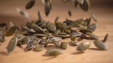 Pumpkin seeds falling in slow motion Stock Footage 55378180