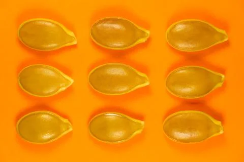 Pumpkin Seeds Pattern Layout On Bright Orange Stock Photos