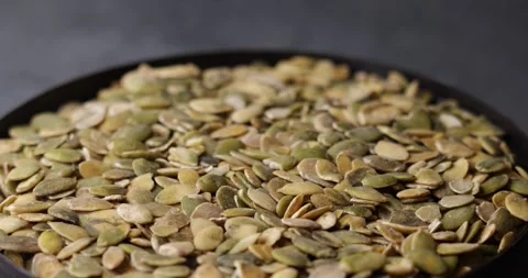 Pumpkin seeds rotating in macro tilt shift seamless loop Video stock 320980222