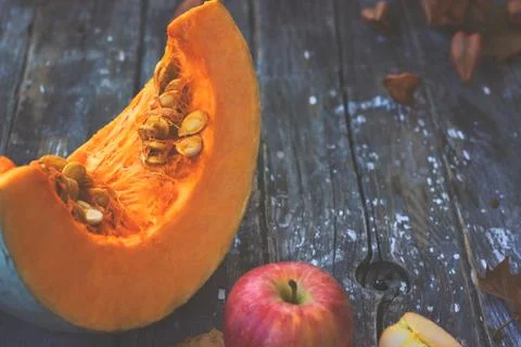 Pumpkin slice with seeds and apple on wooden background 写真素材