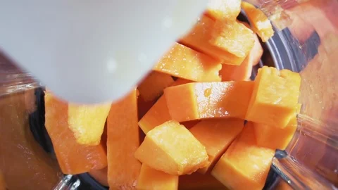Pumpkin slices fall into blender, slow motion. Orange smoothie in blender. Stock Footage 127158720
