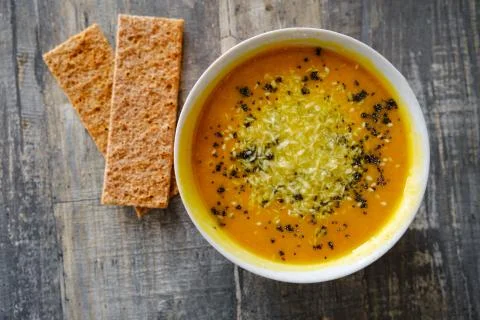 Pumpkin soup with bread on a wooden tabletop, top view Foto stock