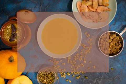 Pumpkin soup in a pot with toasted bread slices and pumpkin seeds Stock Photos