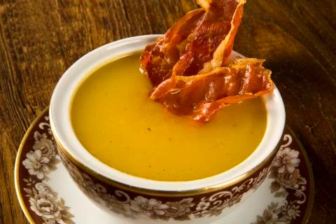 Pumpkin Soup with proschiuto on table Stock Photos