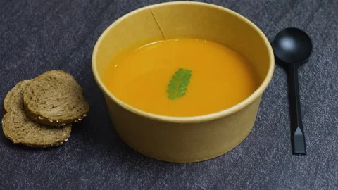 Pumpkin soup served in an eco friendly bowl, paired with slices of toasted bread Video stock 314893618