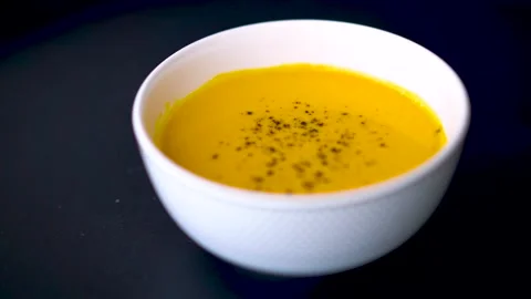 Pumpkin soup shot on a black background Stock Footage 224317735