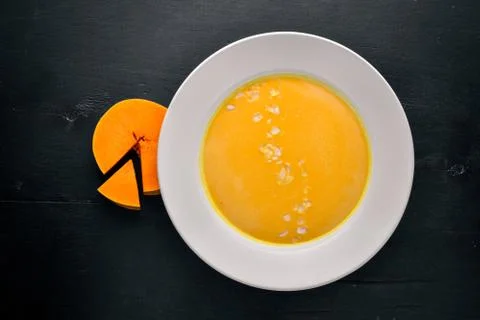 Pumpkin Soup. On a wooden background. Top view. Free space for text. Stock Photos