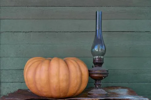The pumpkin stands on a gray background, on a rusty iron sheet. Stock Photos