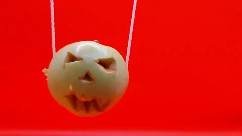 A pumpkin sways against a red background—a Halloween celebration. Stock Footage 344455276
