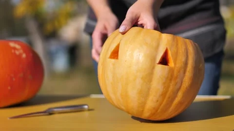 Pumpkin with two triangular eyes on the table. step-by-step instructions Stock Footage 253218124