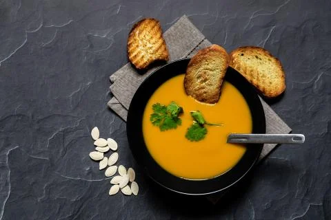 Pumpking soup served with bread top view Stock Photos