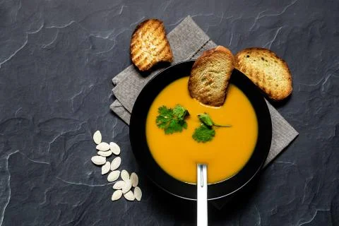 Pumpking soup served with bread top view Stock Photos