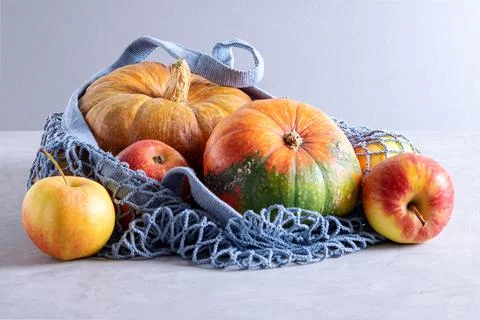 Pumpkins and apples in environmentally friendly reusable mesh bag Stock Photos