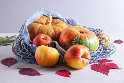 Pumpkins and apples in environmentally friendly reusable mesh bag Stock Photos
