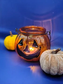 Pumpkins and candlestick decor on a blue background, close-up. Halloween Stock Photos