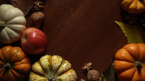 Pumpkins apples walnuts on countertop. Rustic kitchen scene with warm lighting Stock Photos