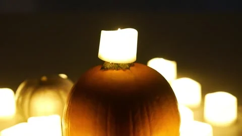 Pumpkins with candles flickering around them. Static shot. Halloween season Stock Footage 253829401