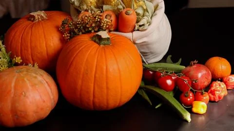 Pumpkins, cherry tomatoes, pepper evoke festive harvest scene. Rustic charm and Stock Photos