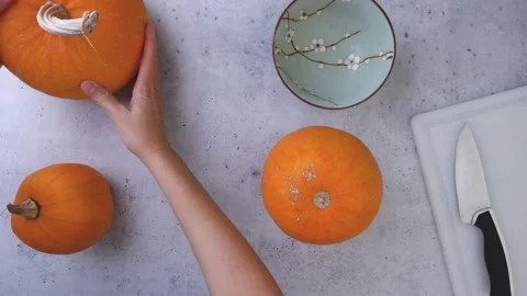 Pumpkins close up on grey background, flat lay, woman hands Stock Footage 164507131