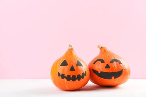 Pumpkins with painted faces on a colored background for Halloween. Stock-Fotos