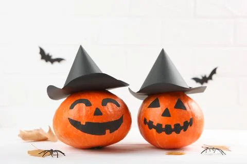 Pumpkins with painted faces on a colored background for Halloween. Stock Photos
