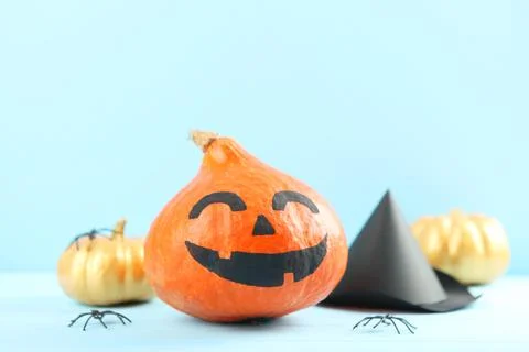 Pumpkins with painted faces on a colored background for Halloween. Stockfoto's