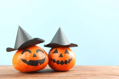 Pumpkins with painted faces on a colored background for Halloween. Stock Photos