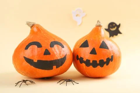 Pumpkins with painted faces on a colored background for Halloween. Stock Photos