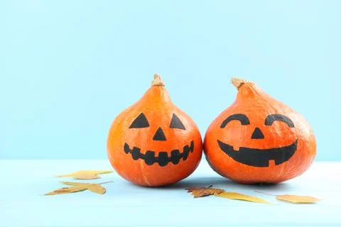 Pumpkins with painted faces on a colored background for Halloween. Stockfoto's