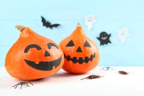 Pumpkins with painted faces on a colored background for Halloween. Stock Photos