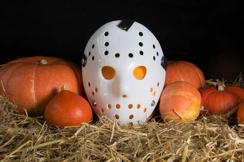 Pumpkins in straw with a Janson mask Stock Photos
