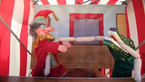Punch and crocodile puppet fighting over pretend sausages Stock Footage 84677350