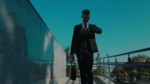 Punctuality in Style White Collar Worker walking Glances at Watch in Urban Stock Footage 254370520