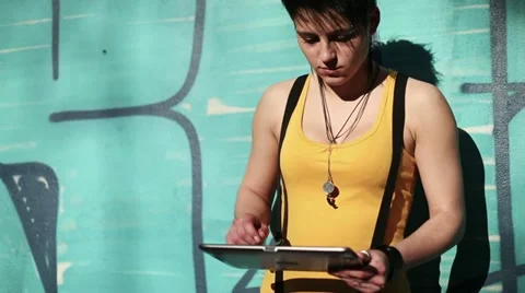 Punk girl with tablet computer standing by the wall, steadicam shot HD Stock Footage