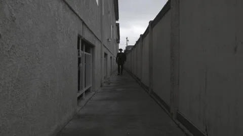 Punk guy walks down alley Stock Footage