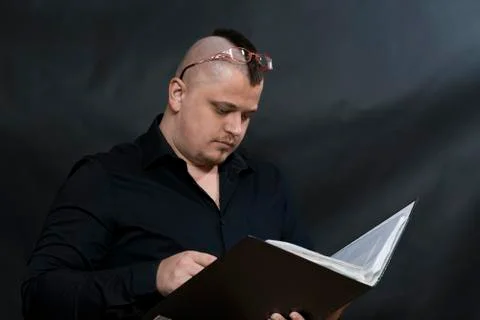 Punk stands with a working folder. Black shirt. Iroquois. Glasses shifted on his Stock Photos