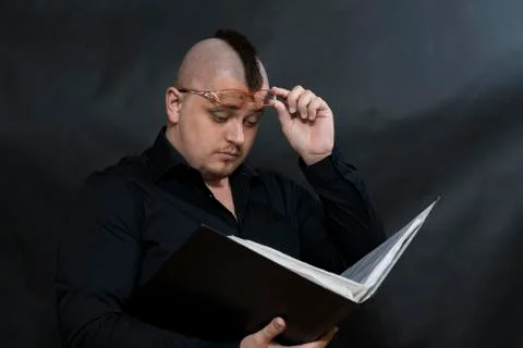 Punk stands with a working folder. Black shirt. Iroquois. Left hand holds rim Stock Photos