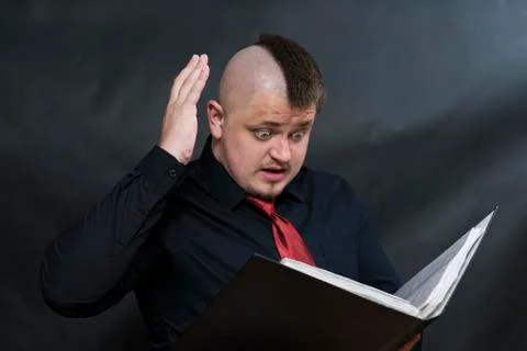 Punk stands with a working folder. One hand is raised above the head. Facial Foto stock
